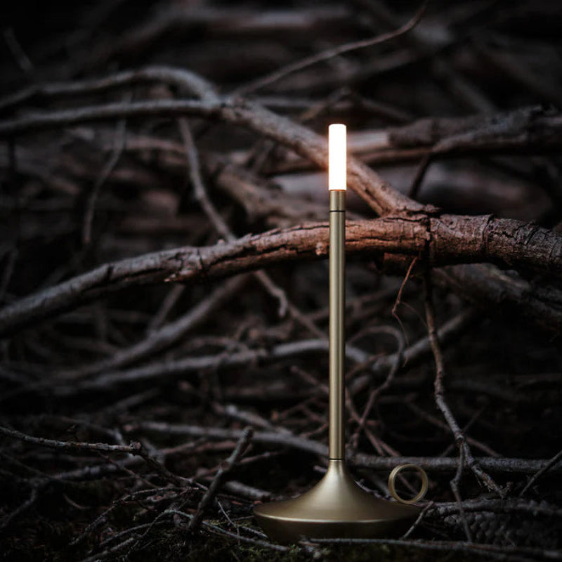 Silver portable candle lamp shown in use outside.