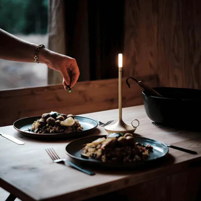 Portable candle lamp illuminating a table with soft, flickering light.