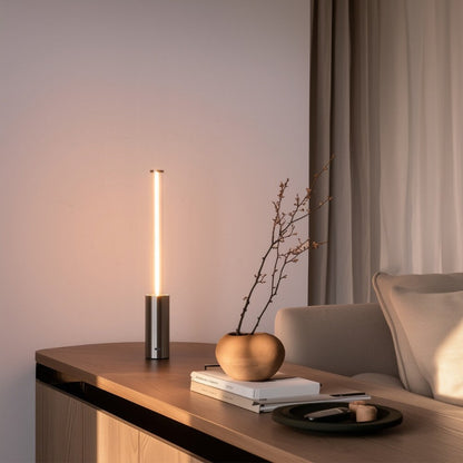 Modern interior with a table lamp, books, and decorative items on a wooden surface.
