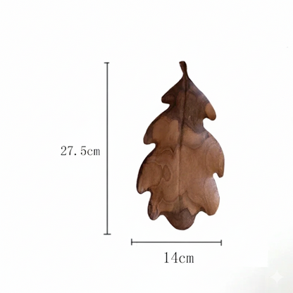 A dark brown wooden decorative tray or dish shaped like a lobed oak leaf, with dimensions marked as 27.5 CM in height and 14 CM in width, set against a plain white background.