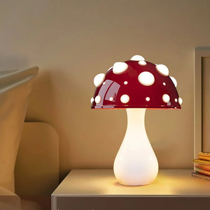 A mushroom-shaped lamp with a dark red cap and white spots, on a nightstand.