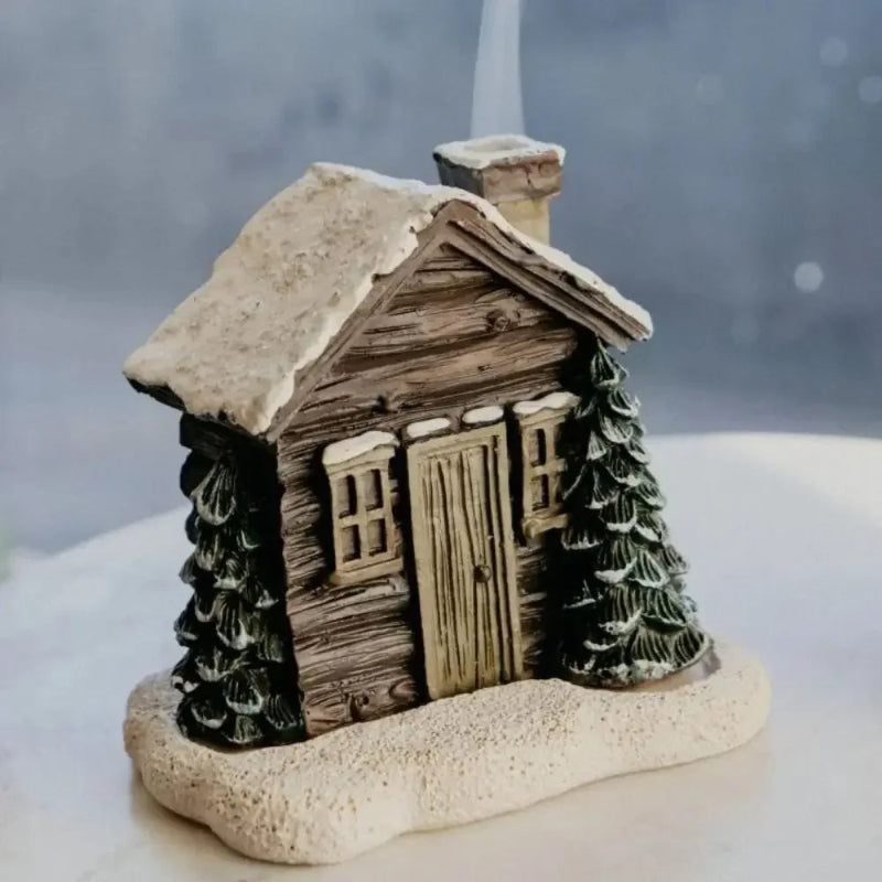 Decorative miniature cabin with trees on a white surface