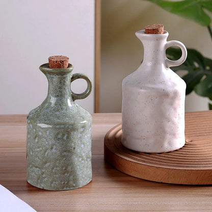 Two ceramic bottles with cork stoppers on a wooden surface.