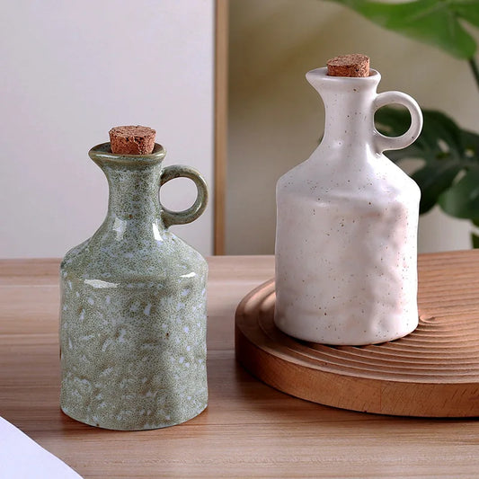Two ceramic bottles with cork stoppers on a wooden surface.