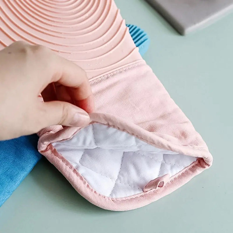 Close-up of a pink fabric product with a white interior on a light green surface.