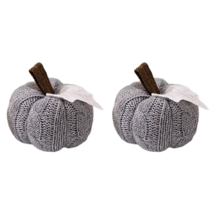 Two identical gray knitted pumpkins, each with a brown stem and a white leaf, isolated on a white background.