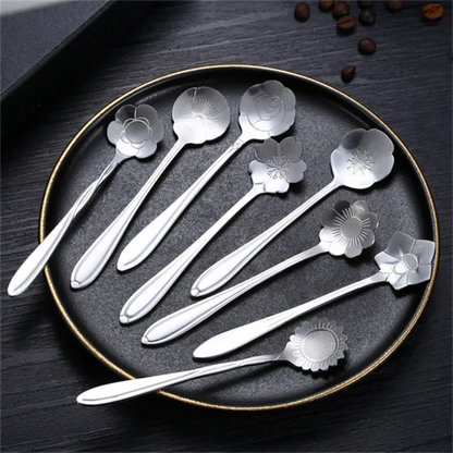 Silver flower spoons on a black tray.