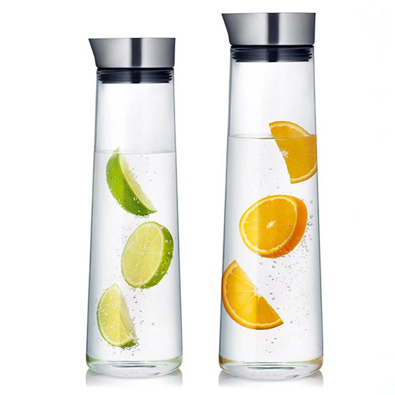 Two glass carafes with metal lids, one with lime slices and the other with orange slices in the water.