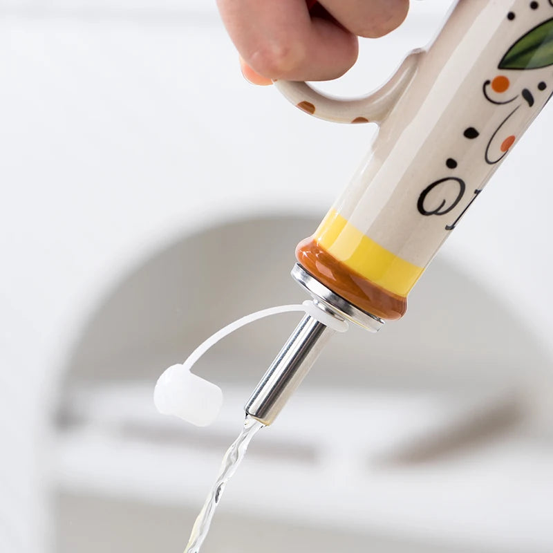Hand holding a decorative kitchen tool with water flowing out against a neutral background