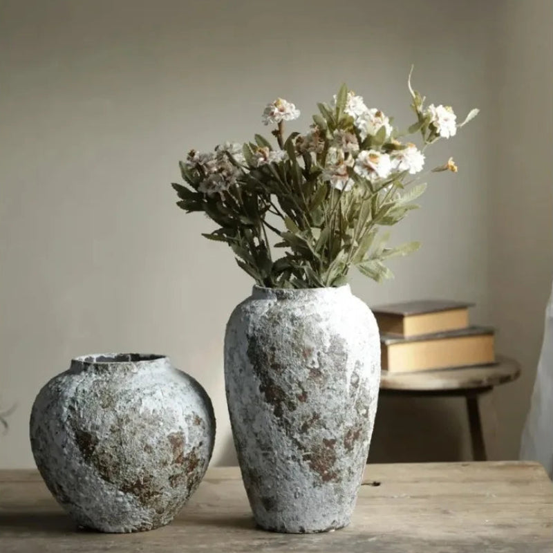 Two textured vases on a wooden surface with a neutral background
