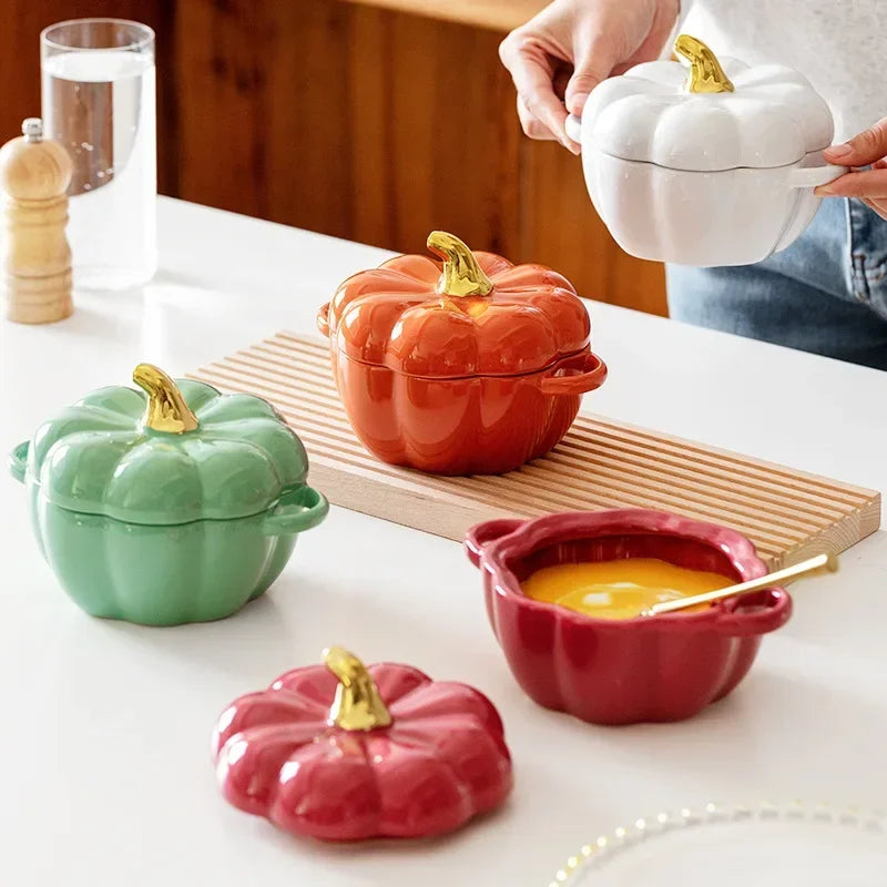 A set of ceramic pumpkin-shaped bowls in various colors being used to serve food. The bowls have a ridged exterior and a stem handle on top.