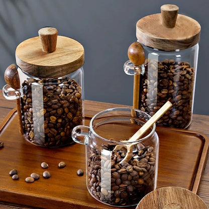 Glass jars with wooden lids filled with coffee beans on a wooden surface.