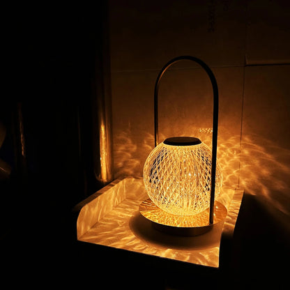 A modern, spherical glass lamp with a criss-cross pattern glowing in a dark room, casting light patterns on a surface.