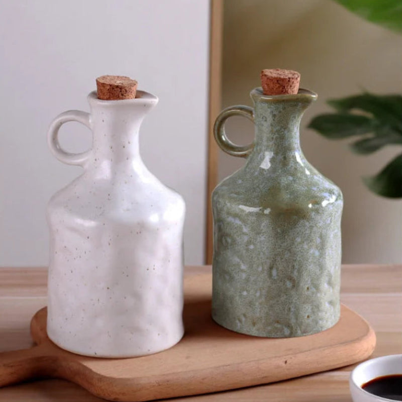 Two ceramic bottles with cork lids on a wooden tray.