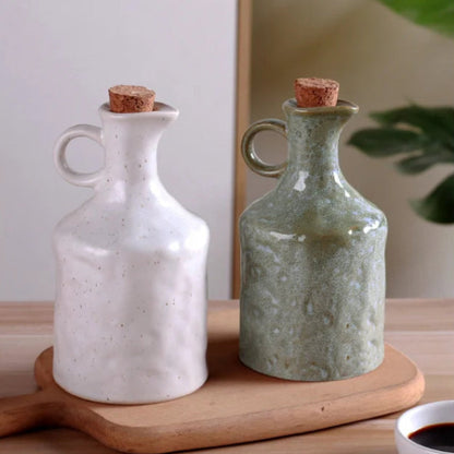 Two ceramic bottles with cork lids on a wooden tray.