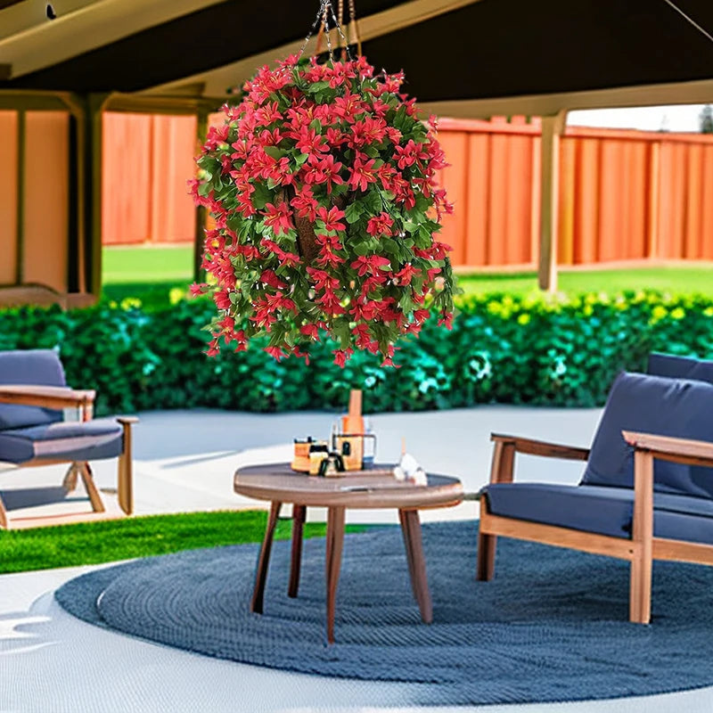 Hanging basket of artificial red flowers over an outdoor seating area.