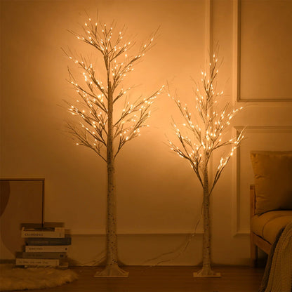 Two illuminated decorative trees in a room with warm lighting.