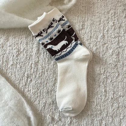 White sock with black and blue pattern on a textured beige surface
