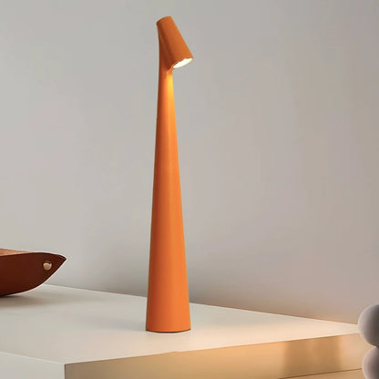 A sleek, modern, orange lamp with a narrow, tall base and a small light at the top, standing on a white surface.