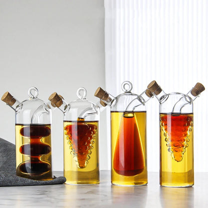 Set of four glass bottles with cork stoppers containing different liquids on a light surface.