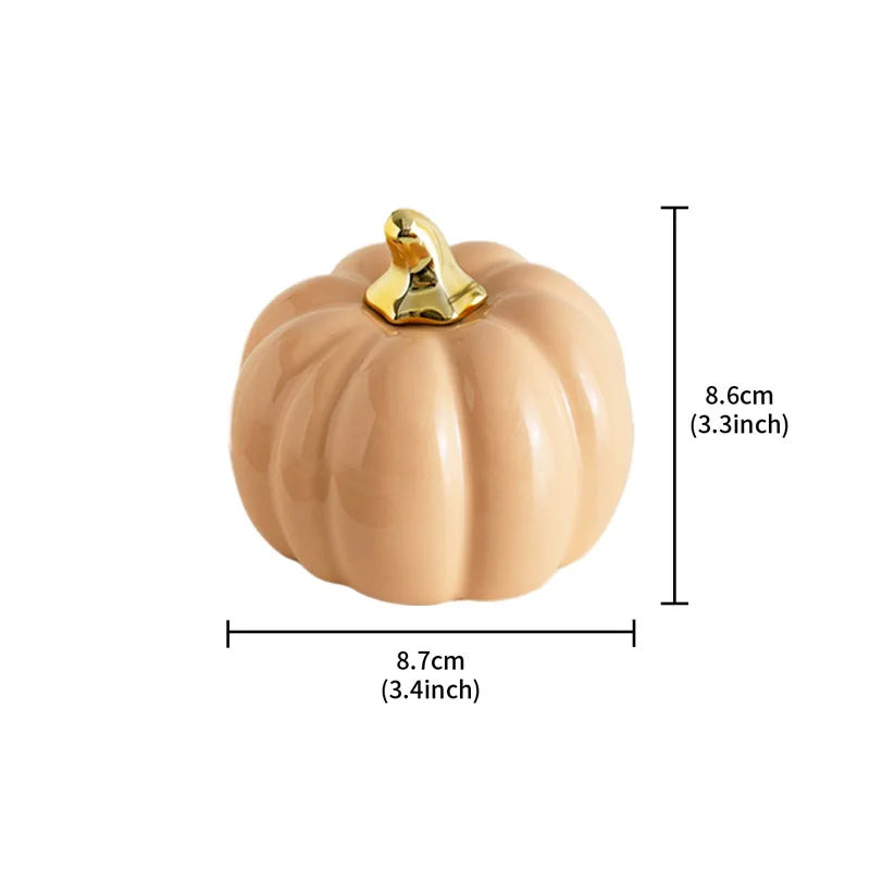 A light brown ceramic pumpkin with a gold stem is shown with its dimensions: 8.7cm (3.4 inches) wide and 8.6cm (3.3 inches) tall.