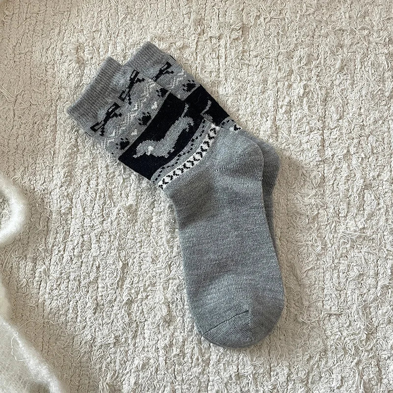 Gray socks with black pattern on a textured beige surface