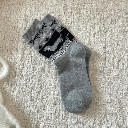 Gray socks with black pattern on a textured beige surface