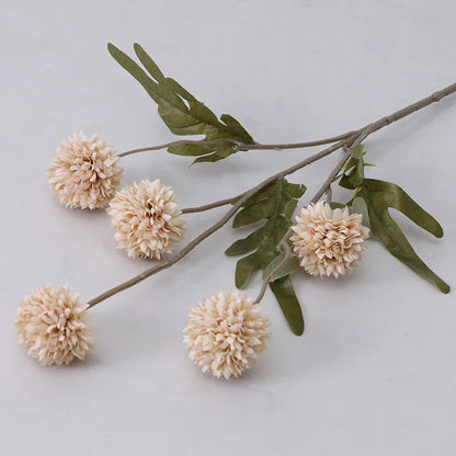 A single stem of artificial beige dahlia flowers with green leaves.