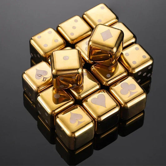 Gold dice cubes with playing card suits on a reflective black surface