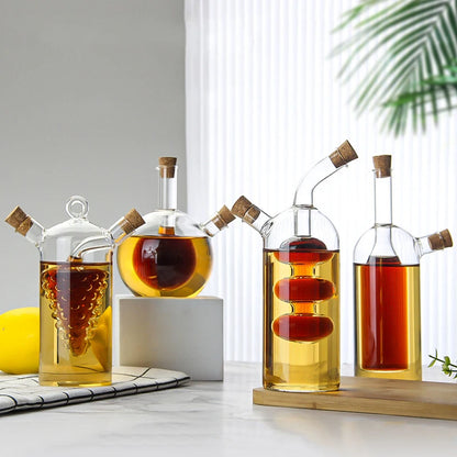 Set of glass oil and vinegar bottles with wooden caps on a white surface.