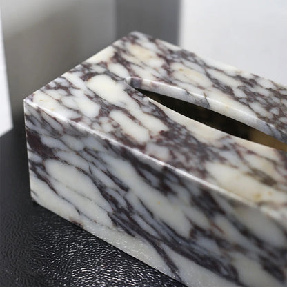 Marble-patterned tissue box on a black surface