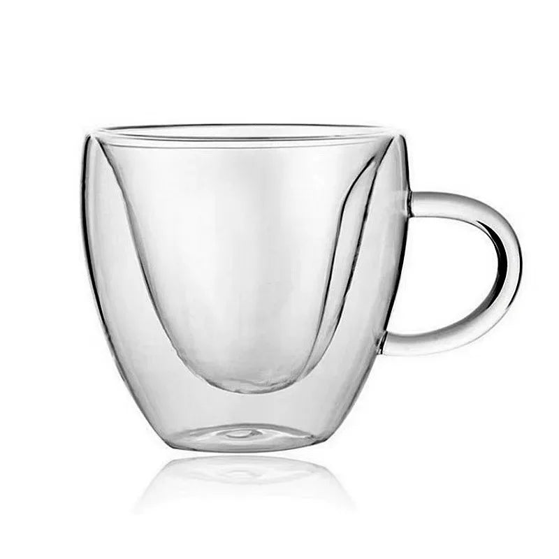 A clear, empty, double-walled glass mug with a heart-shaped inner wall and a handle on the right.