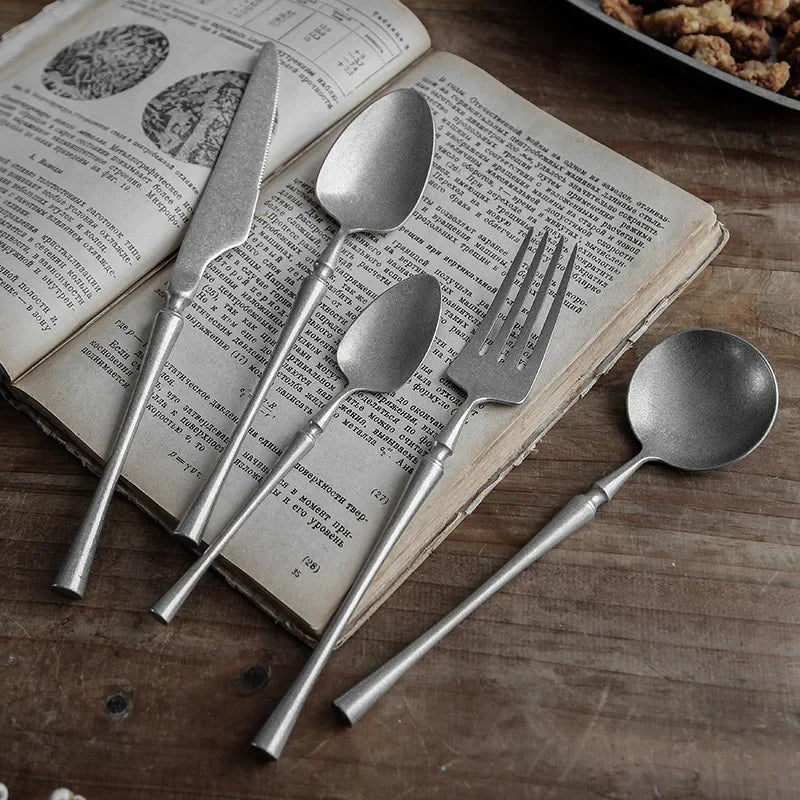 Antique silverware on open book