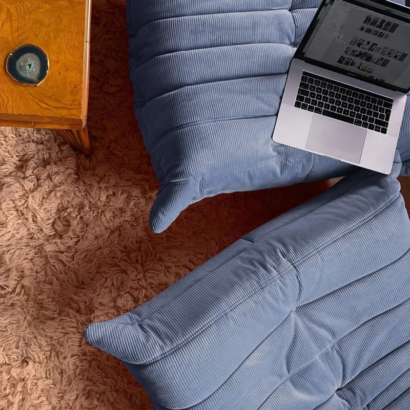 Overhead view of a laptop on a blue sofa.