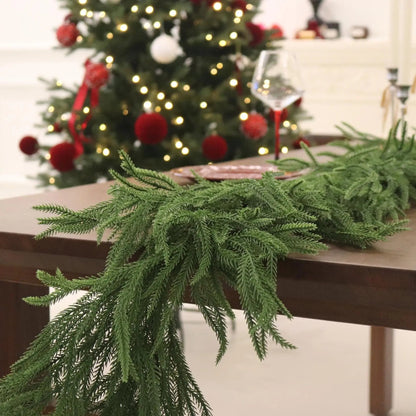 Green table runner on a wooden table with a decorated Christmas tree in the background.