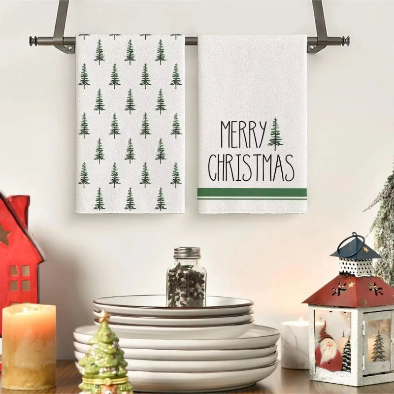 Two Christmas-themed towels hanging on a rack with decorative items below.