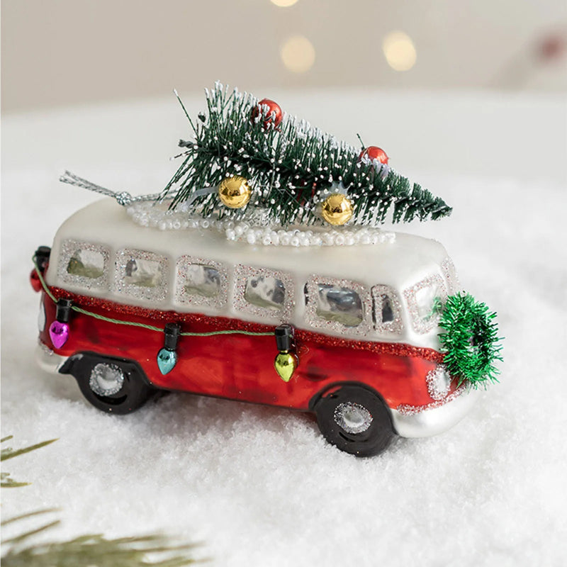 Decorative red and white bus ornament with Christmas tree on a snowy background