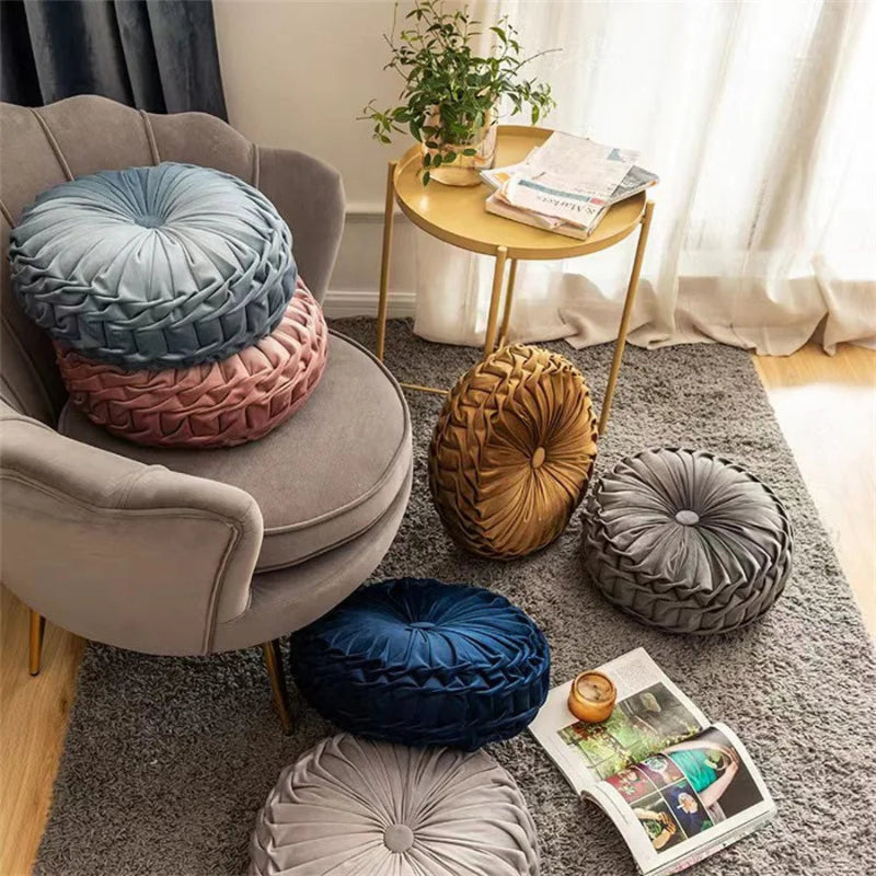 Decorative round pillows on a chair and floor in a living room setting.