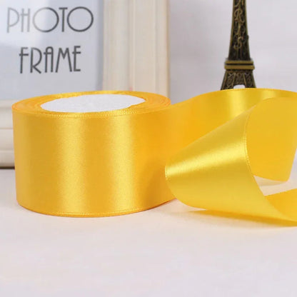 Yellow satin ribbon with a photo frame in the background