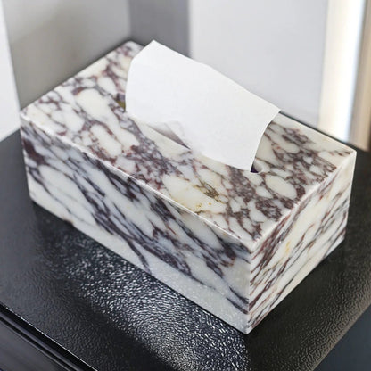 Marble-patterned tissue box on a black surface