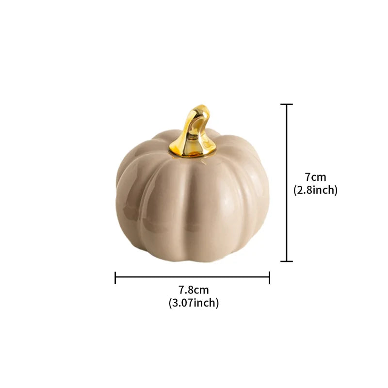 A small, gray-colored ceramic pumpkin with a gold stem is shown with its dimensions: 7.8cm (3.07 inches) wide and 7cm (2.8 inches) tall.