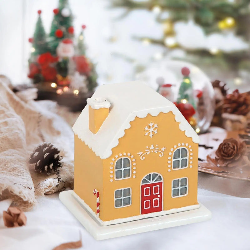 Decorative gingerbread house on a table with Christmas decorations in the background