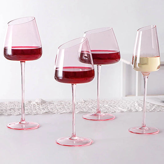 Four stemmed glasses with an angled rim, three filled with red wine and one with white wine.
