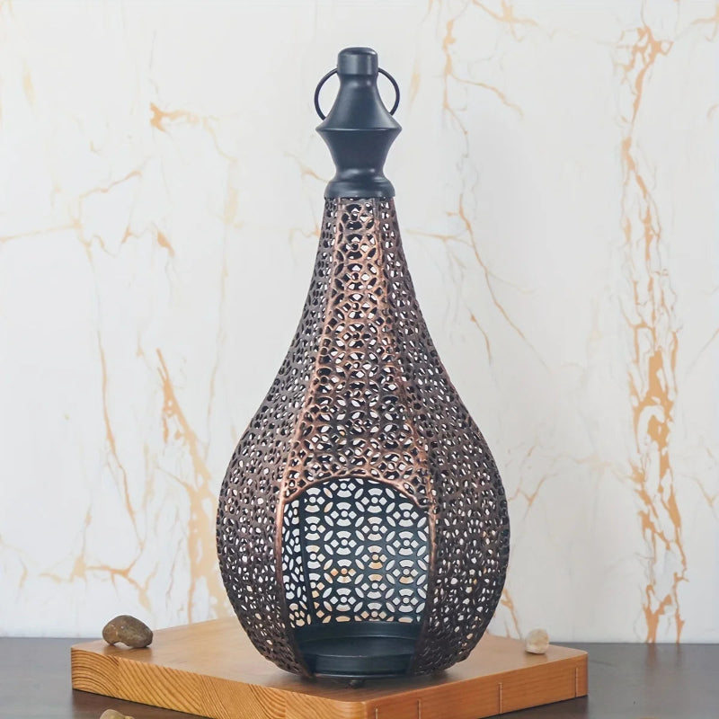 A single unlit ornate metal lantern with a black top sits on a wooden base, set against a light brown patterned wall.