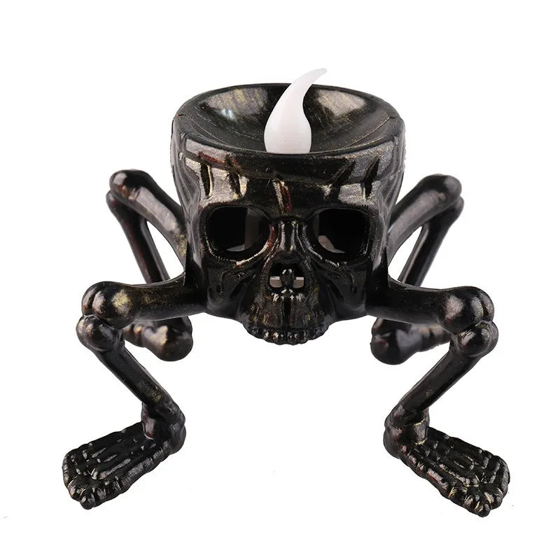 A Halloween candle holder shaped like a skull with skeletal legs, on a white background.