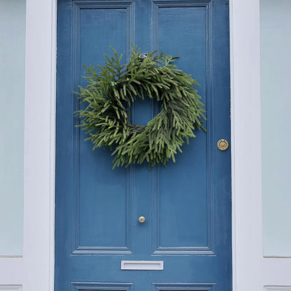 A simple green wreath on a blue door.