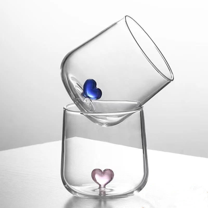 Two clear glasses with heart-shaped bottoms.