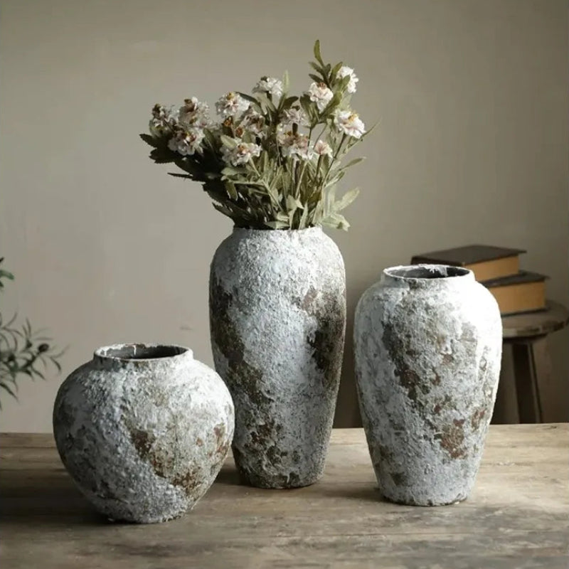 Three textured vases on a wooden surface with a neutral background