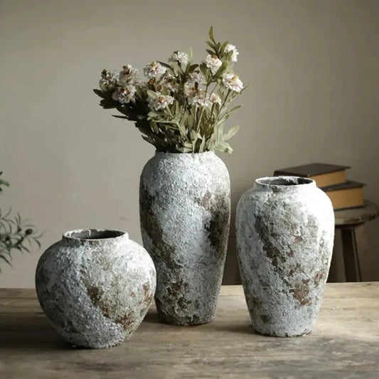 Three textured vases on a wooden surface with a neutral background