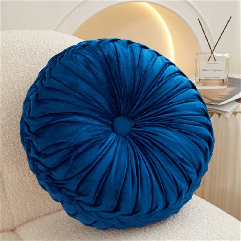 Blue round pillow on a beige sofa with a blurred background